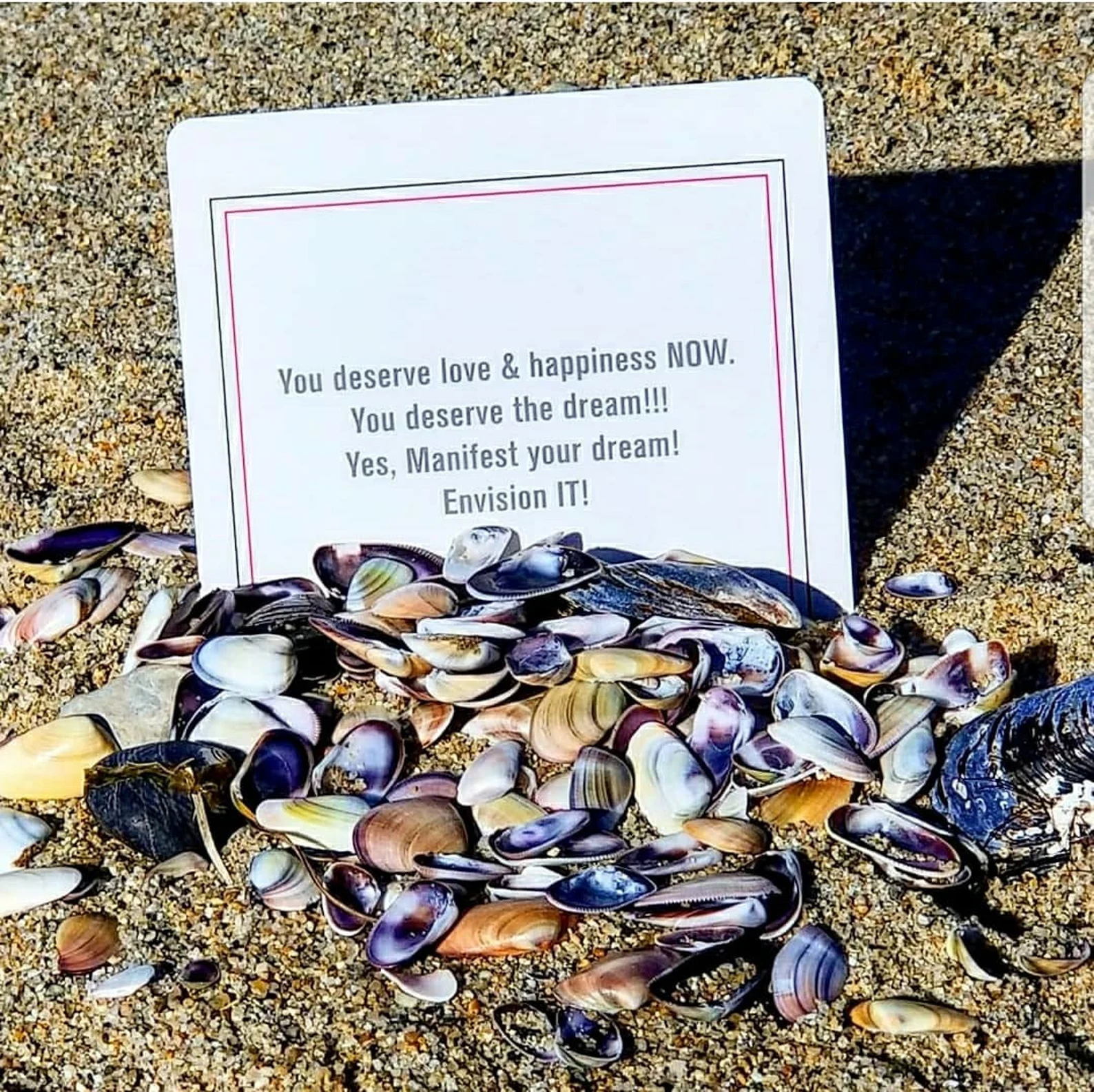 Affirmation card held up at the beach
